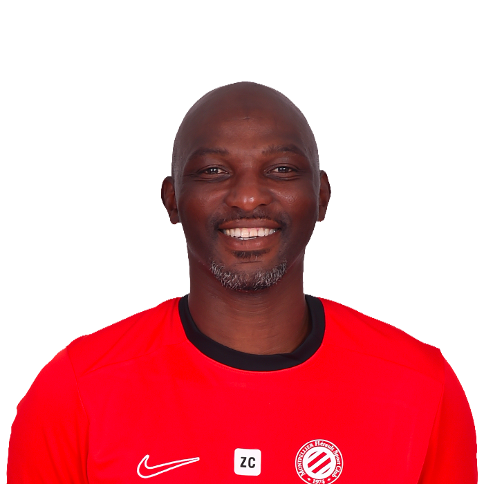 Smiling man in a red sports jersey facing the camera, portrait-style photo.