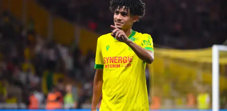 aux-arts-de-benhattab | AllezPaillade.com Soccer player in yellow and green kit on the field, pointing with his right hand during a match.